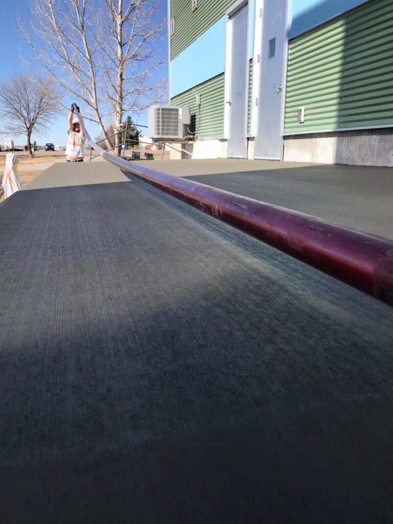 one of our team members rolling the finish pattern on some concrete