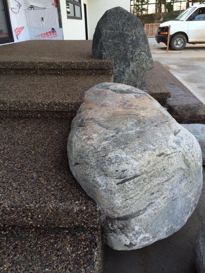 Large rock embedded into exposed aggregate stairs
