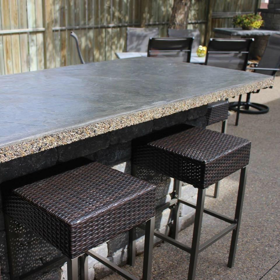 concrete patio with concrete table and some wicker chairs
