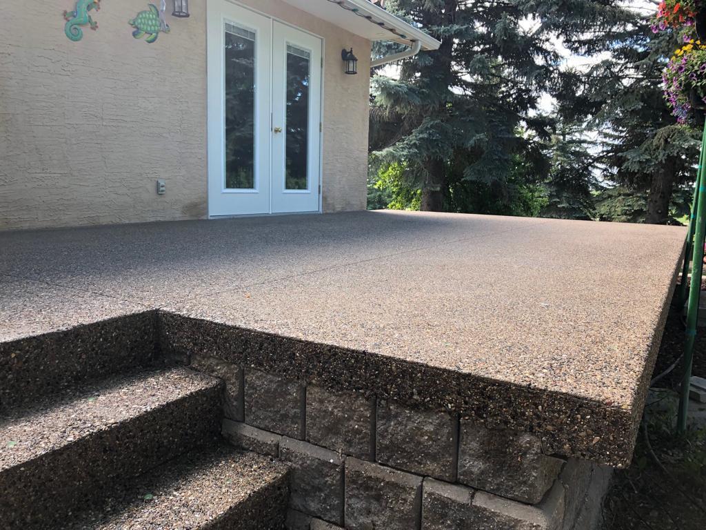 concrete patio deck with some stairs up to the house